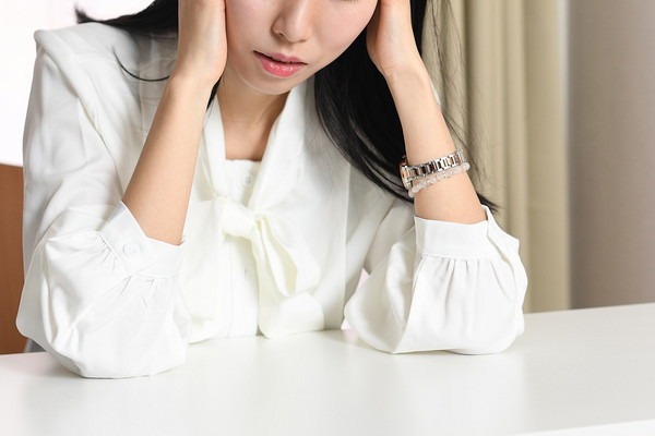 頭を押さえる女性