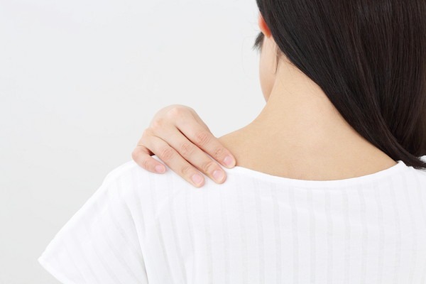 肩を触る女性