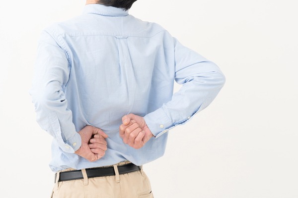 腰をたたく男性