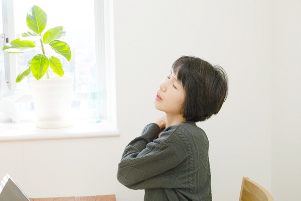 肩を押さえる女性