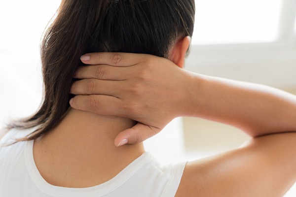 首を押さえる女性