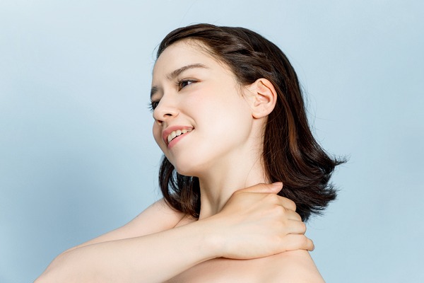 笑顔で肩を触る女性