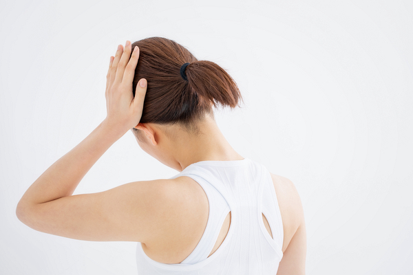 頭を押さえる女性