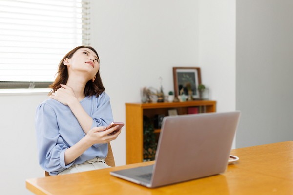 首を押さえる女性