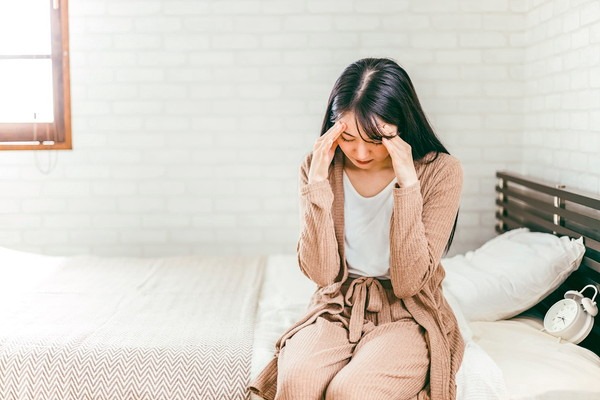 頭を押さえる女性