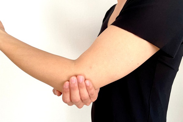 肘を押さえる男性